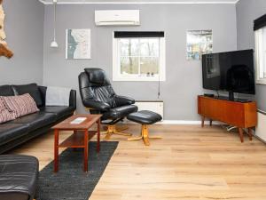 uma sala de estar com um sofá e cadeiras e uma televisão em 5 person holiday home in Skærbæk em Skærbæk