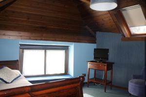 a bedroom with a bed and a window and a television at Hotel Casa Estampa in Escuñau