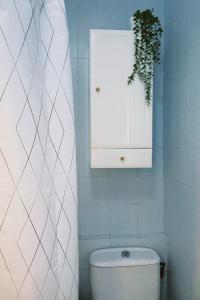 een badkamer met een toilet en een kast en een plant bij Apartamento estación de Portbou in Portbou