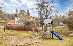un parque infantil con tobogán y columpio en Stunning Apartment In Hlleforsns With Wifi And 2 Bedrooms, en Hälleforsnäs