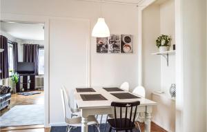 a white dining room with a white table and chairs at Stunning Apartment In Hlleforsns With Wifi And 2 Bedrooms in Hälleforsnäs
