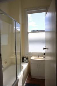 een badkamer met een douche, een wastafel en een raam bij Stay at the historic Star Hotel in Sale