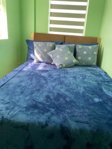 a bed with a blue comforter and pillows at Camella Homes in Tagbilaran City