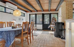 uma cozinha com uma mesa e cadeiras e uma lareira em 4 Bedroom Lovely Home In Blvand em Blåvand