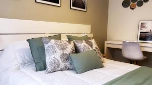 - une chambre avec un lit blanc et des oreillers dans l'établissement Bilbao Matiko Tranquility near the Old town, à Bilbao