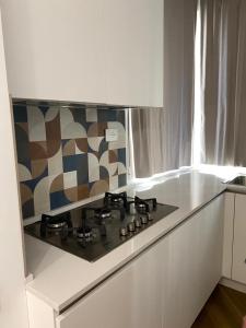 uma cozinha com uma placa de fogão numa cozinha branca em Guest House Josephine em Salerno