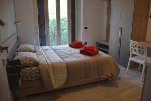 a bedroom with a bed with red pillows on it at B&B Alba Chiara in Paola
