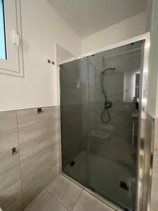 a shower with a glass door in a bathroom at Palm beach appartment 80 mt dal mare e comodo per Venezia in Lido di Jesolo