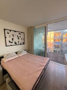 a large bed in a room with a large window at Palm beach appartment 80 mt dal mare e comodo per Venezia in Lido di Jesolo