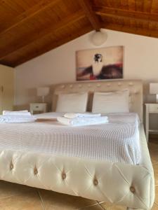 1 cama blanca grande con sábanas y almohadas blancas en Hera Loft en Iraio
