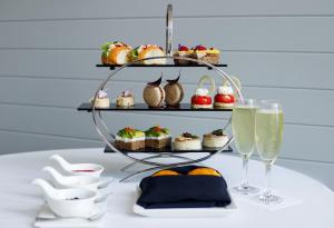 Una mesa con un plato de postres y copas de champán. en Pullman Cairns International, en Cairns