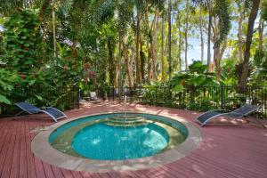 a swimming pool in the middle of a garden at Belle Escapes Drift Beachfront Resort Suite 3409 in Palm Cove