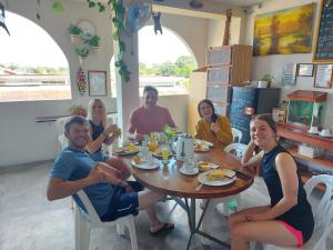a group of people sitting around a table eating at Amazon House Hostel in Iquitos