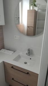 y baño con lavabo blanco y espejo. en Logement Place d'Erlon hypercentre avec balcon, en Reims