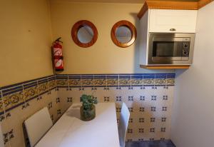 a kitchen with a table and a microwave at Sopelana pueblo muy cerca de la playa ideal para surfistas y familias. in Sopelana +5 photos