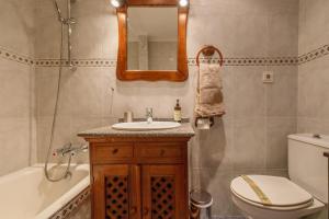 a bathroom with a sink and a toilet and a mirror at Sopelana pueblo muy cerca de la playa ideal para surfistas y familias. in Sopelana