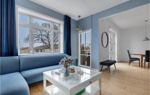 uma sala de estar com um sofá azul e uma mesa em Beautiful Home In Nex With Wifi em Neksø