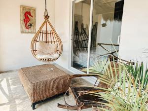 a room with a chair and a swing at Hotel Nicte Ha Tulum in Tulum