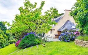 un jardín frente a una casa con flores en Villa Saint Kirio - piscine et spa en Morlaix