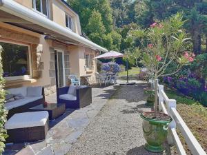 een patio van een huis met een boom in een vaas bij Villa Saint Kirio - piscine et spa in Morlaix