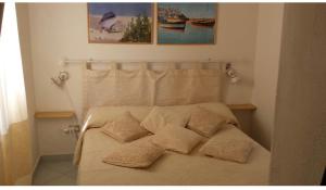 1 cama con 4 almohadas en el dormitorio en Appartamento a 200MT da "La Pelosa" en Stintino