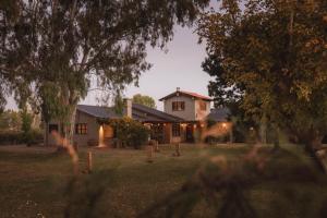 una casa por la noche con las luces encendidas en Posada Mawida en Maipú