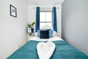 a bedroom with a bed with two heart shaped towels at Comfy 4 bed house close to station and theatre in London