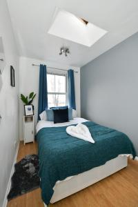 a bedroom with a large bed with blue curtains at Comfy 4 bed house close to station and theatre in London