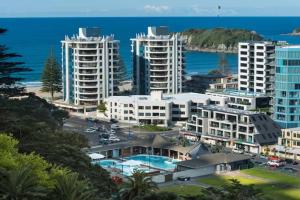 - une vue aérienne sur une ville avec des bâtiments et l'océan dans l'établissement Oceanside Apartment with Iconic Views, à Mount Maunganui