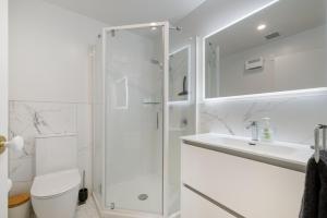 a bathroom with a shower and a toilet and a sink at Oceanside Apartment with Iconic Views in Mount Maunganui +16 photos
