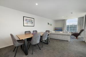 - une salle à manger avec une table, des chaises et un canapé dans l'établissement Oceanside Apartment with Iconic Views, à Mount Maunganui