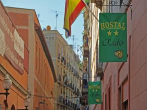 a street with some signs on the side of buildings at Hostal Radio Barcelona in Barcelona