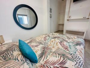 Dormitorio con cama con almohada azul y espejo en Hotel Nicte Ha Tulum en Tulum