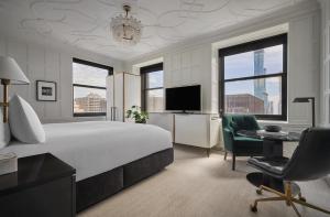 a hotel room with a bed and a desk and a television at Pendry Chicago in Chicago