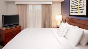 ツーソンにあるResidence Inn by Marriott Tucson Williams Centreのベッドとテレビが備わるホテルルームです。