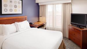 ツーソンにあるResidence Inn by Marriott Tucson Williams Centreのベッド1台、薄型テレビが備わるホテルルームです。