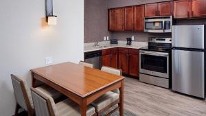 土桑的住宿－Residence Inn by Marriott Tucson Williams Centre，厨房配有木桌、椅子和冰箱