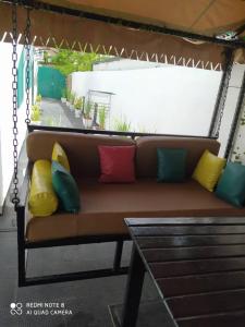 a swing seat with colorful pillows on a porch at Globe-trotter vision C in Cotonou