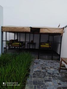 a patio with a roof and a table and bench at Globe-trotter vision C in Cotonou