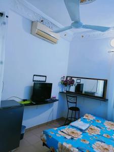 a blue room with a bed and a table and a television at Globe-trotter vision C in Cotonou