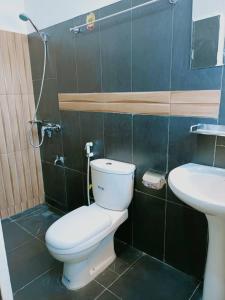 a bathroom with a toilet and a sink at Globe-trotter vision C in Cotonou