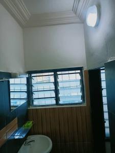 a bathroom with a toilet and a sink and a window at Globe-trotter vision C in Cotonou