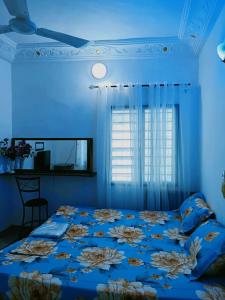 Dormitorio azul con cama y ventana en Globe-trotter vision C en Cotonú
