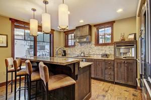 a kitchen with a large island with bar stools at One Ski Hill Place S8309 in Breckenridge