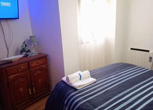1 dormitorio con 1 cama y vestidor con toallas en Acogedor Apartamento Ocaña, en Ocaña