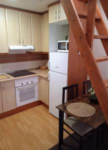 a small kitchen with a white refrigerator and a table at Acogedor Apartamento Ocaña in Ocaña