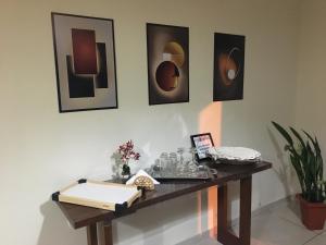 a table in a room with pictures on the wall at Apartamento Central -Centro Cunha in Cunha