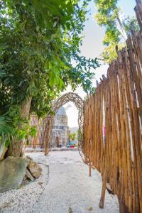 a wooden fence with an arch in front of a building at Jaakbal Tulum in Tulum
