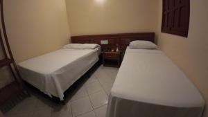 a room with two beds in a room at Hotel Pousada da Lapa in Bom Jesus da Lapa