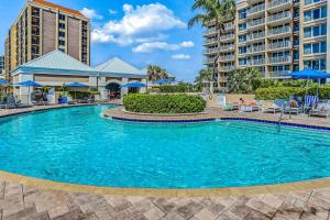 a swimming pool at a resort with chairs and umbrellas at Marco Beach Ocean Resort 614 in Marco Island